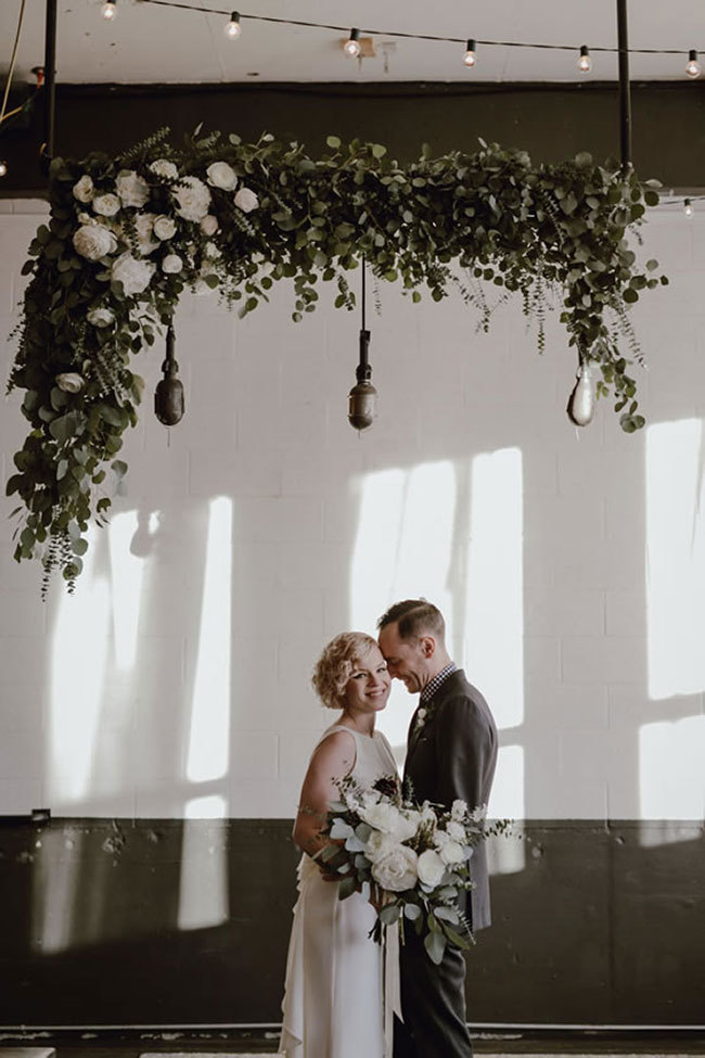 An industrial-wedding ceremony at UNION/PINE with a hanging greenery installation An industrial-wedding ceremony at UNION/PINE with a hanging greenery installation
