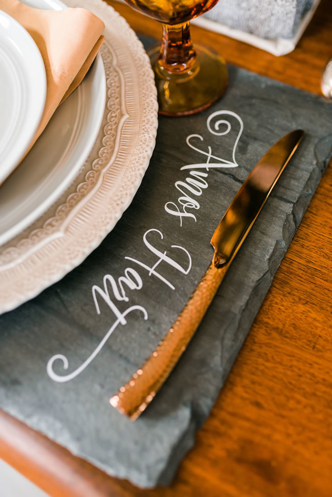 Industrial-chic wedding table setting with stone placemats and copper silverware Industrial-chic wedding table setting with stone placemats and copper silverware