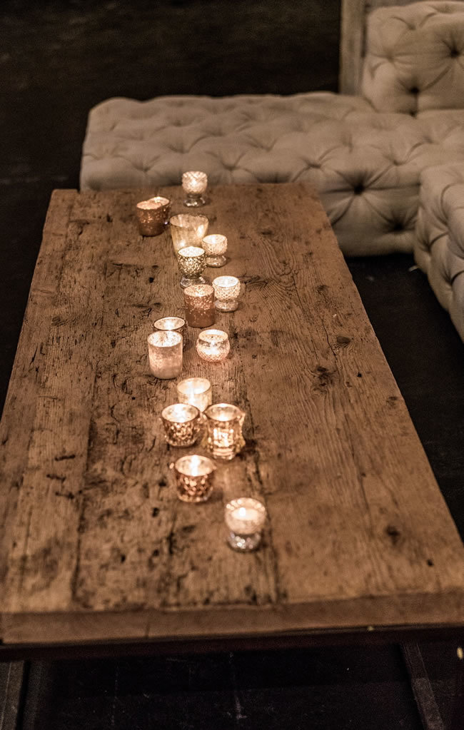 Glowing votive candles on a distressed wood table Glowing votive candles on a distressed wood table