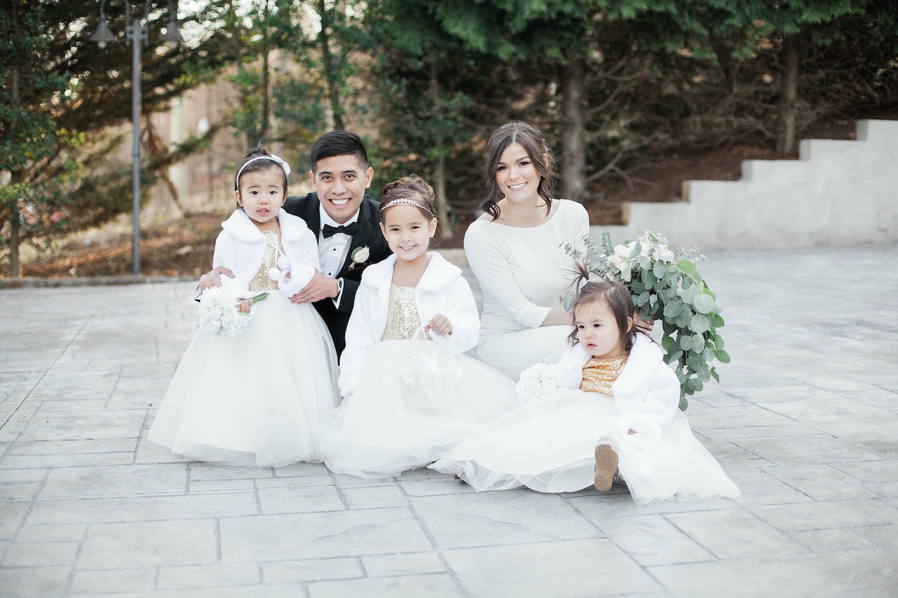 Family-friendly or child-free wedding | Newlyweds pose with their three adorable flower girls