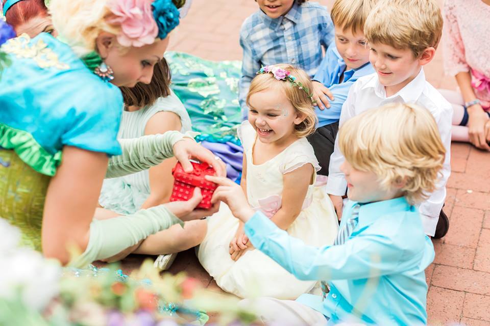 A young wedding guest is delighted by a childcare entertainer dressed like a fairy
