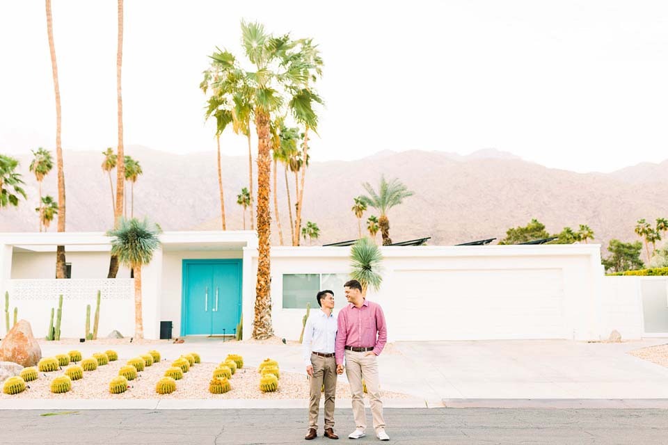 How to propose marriage | A stylish just-engaged duo posing in front of a colorful Palm Springs house