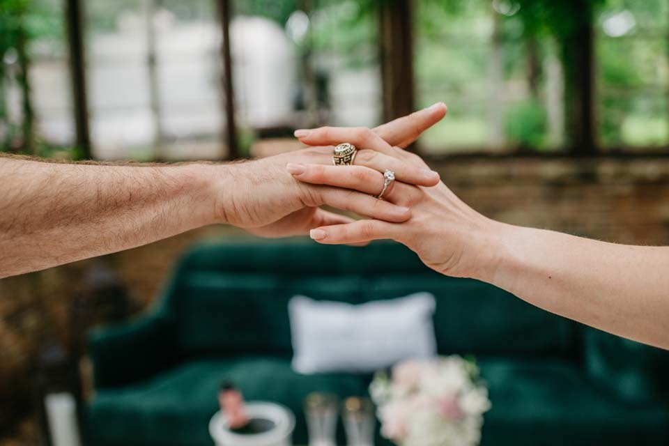 Proposal photo focusing on the couple holding hands and showing off their rings