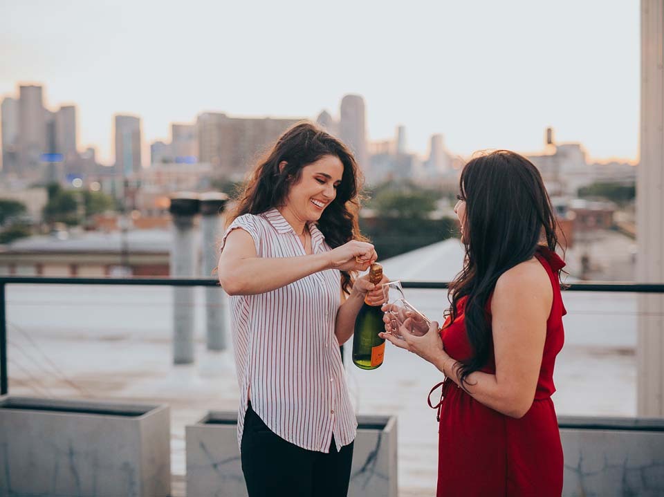 A newly-engaged couple pops champagne after the proposal