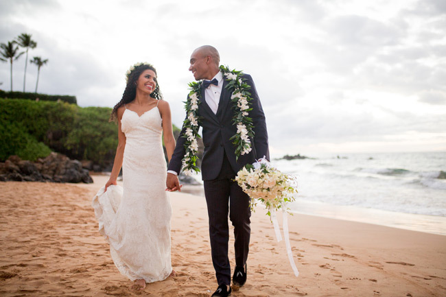 Pros and Cons of a Destination Wedding | A stunning destination wedding couple walks on a Maui beach Pros and Cons of a Destination Wedding | A stunning destination wedding couple walks on a Maui beach