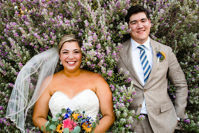 An adorable wedding couple smiling among wildflowers | How to Keep your Wedding Simple An adorable wedding couple smiling among wildflowers | How to Keep your Wedding Simple