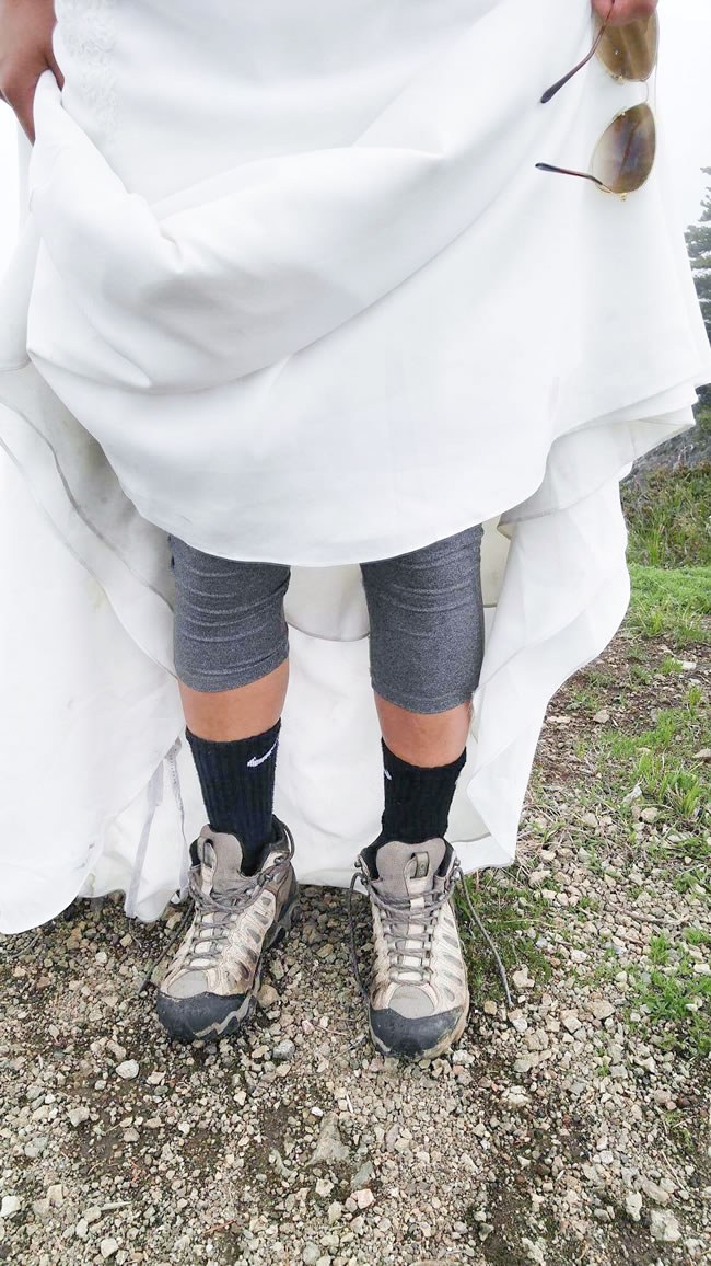 Bride lifting up gown to reveal hiking boots