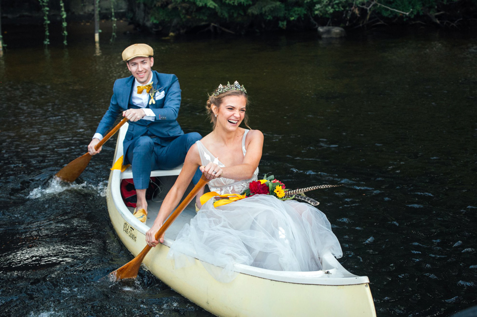 5 Tips for Hosting a Summer Camp Wedding | Newlyweds paddling in a canoe