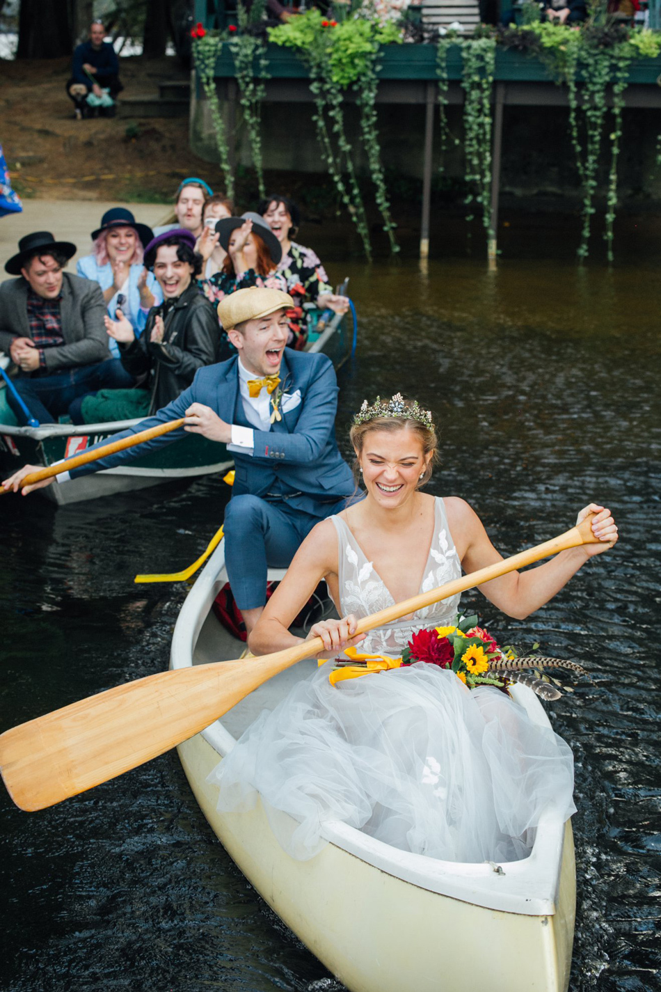 Summer Camp Wedding Inspiration | Newlyweds and guests in canoes Summer Camp Wedding Inspiration | Newlyweds and guests in canoes