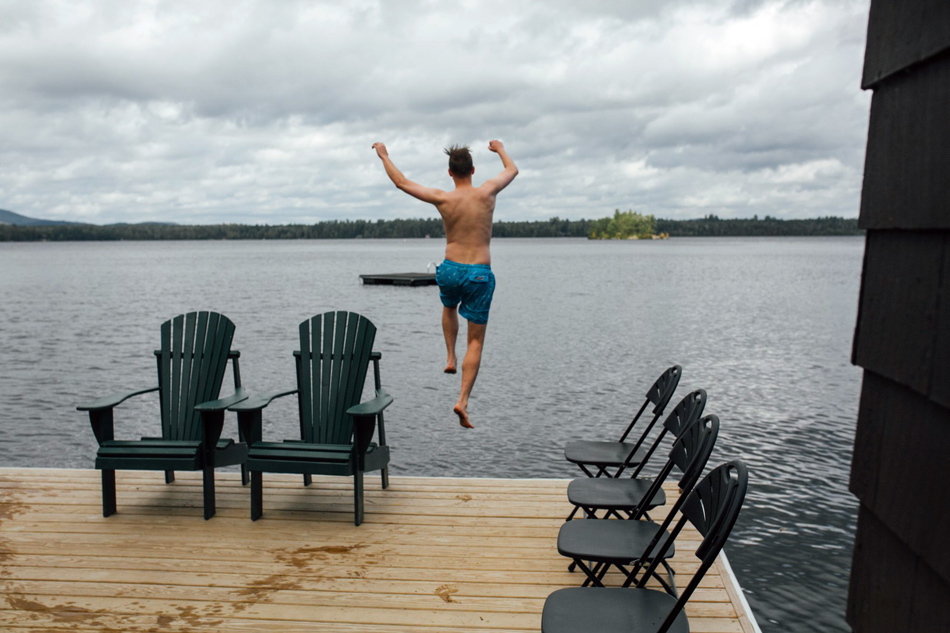 Summer Camp Weddings | Guest jumping into the lake