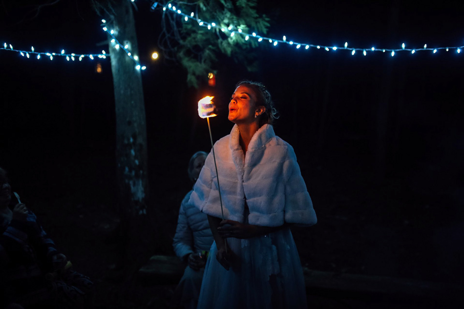 Camp Wedding Inspiration | Bride blows out fire on marshmallow