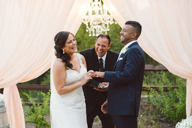 Bride and groom have a laugh with their wedding officiant