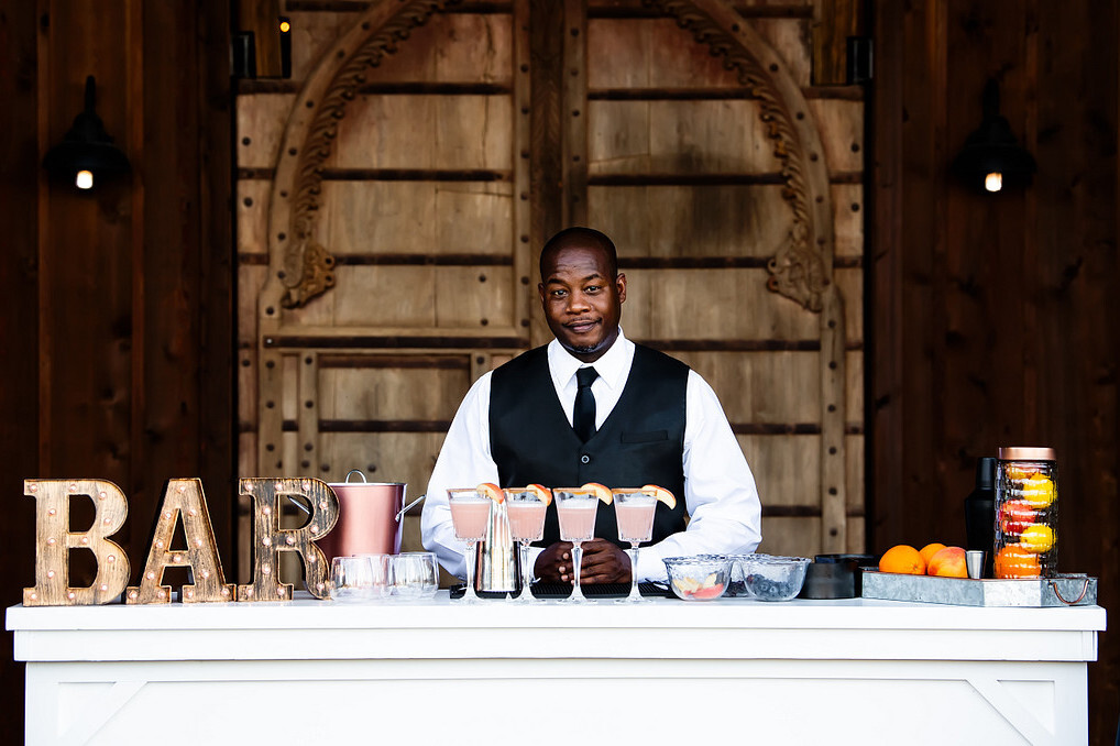 Professional bartender serves drinks at an outdoor wedding bar | Wedding alcohol costs