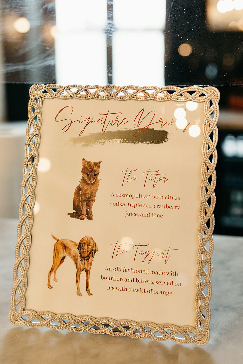 A wedding sign of signature drinks named after the couple's dog and cat