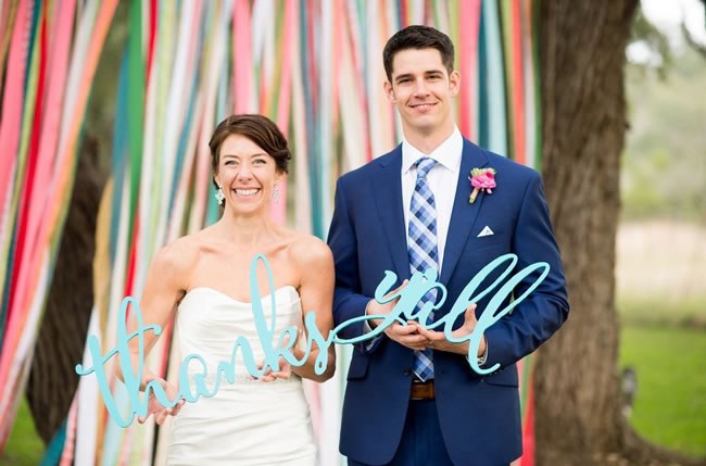 Wedding Thank You Note Etiquette Bride and Groom holding Thanks Y'all wedding sign