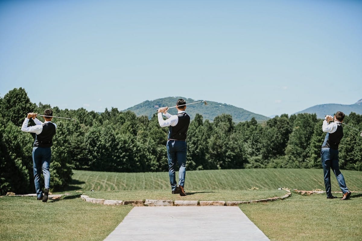 Three groomsmen play golf during a long wedding weekend