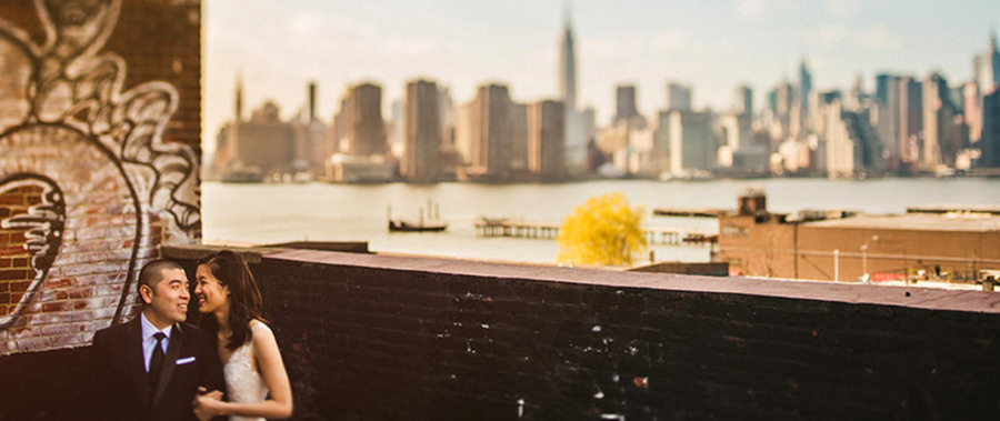 Everything you need to know about getting married in Brooklyn Newlyweds stand in front of Manhattan skyline at Greenpoint Loft in Brooklyn