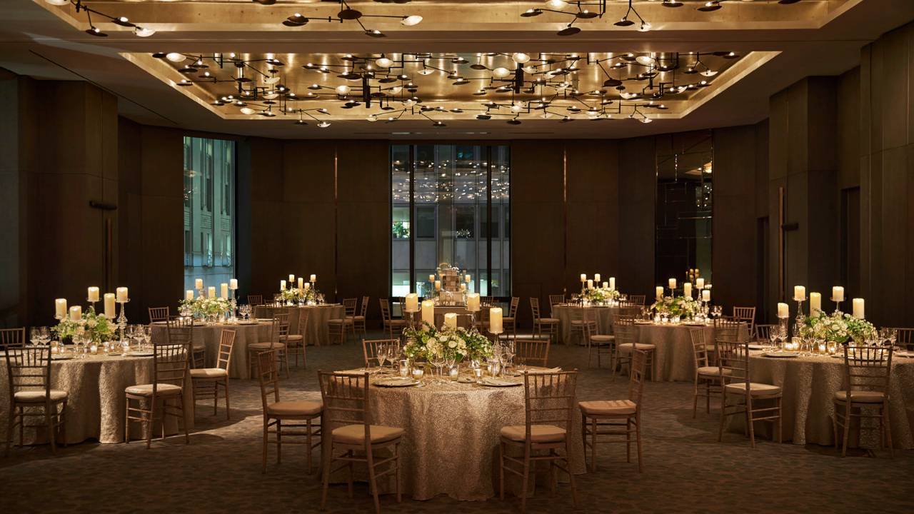 Elegant wedding reception tables with candle centerpieces in ballroom at Seasons New York Downtown