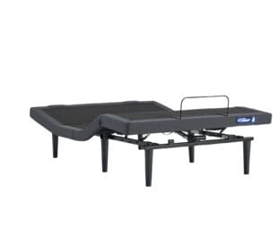 A black adjustable bed frame with raised head and leg sections, showing its ability to elevate and fold at multiple points. The frame has sturdy legs and a gray fabric border.