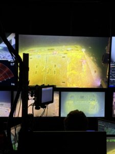 : Inside the Jason control van, the monitor showing the old BEP with barnacles, anemone, and starfish during Dive J2-1776. Credit: J Campbell, University of Washington; V26.