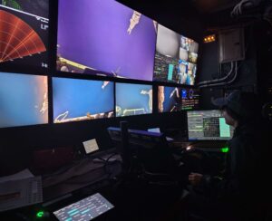 A VISIONS's student practices using the manipulator of Jason in the control van.