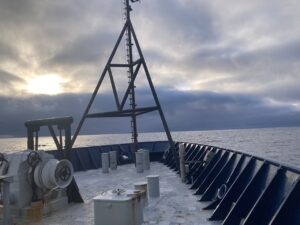 The bow of the Revelle with calm sees and dark clouds on the horrizon