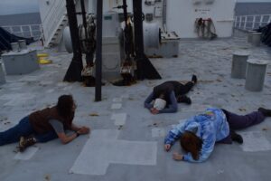 Deck yoga out on the bow. Pictured from left to right: Izzie, Maddy, Avery. J. Campbell, University of Washington. V26.