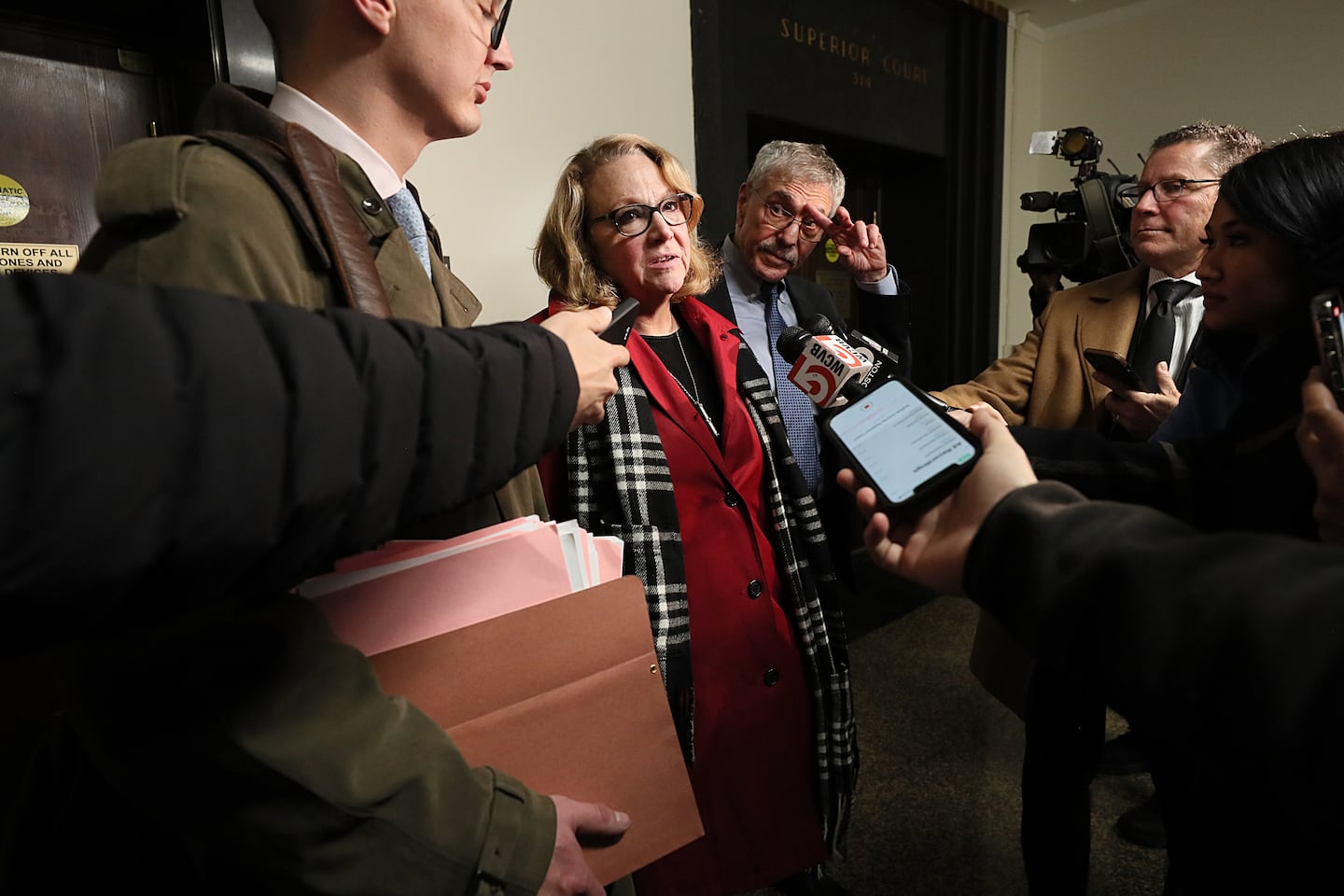 Shannon O'Brien, center,  speaks to reporters in Suffolk Superior Court.
