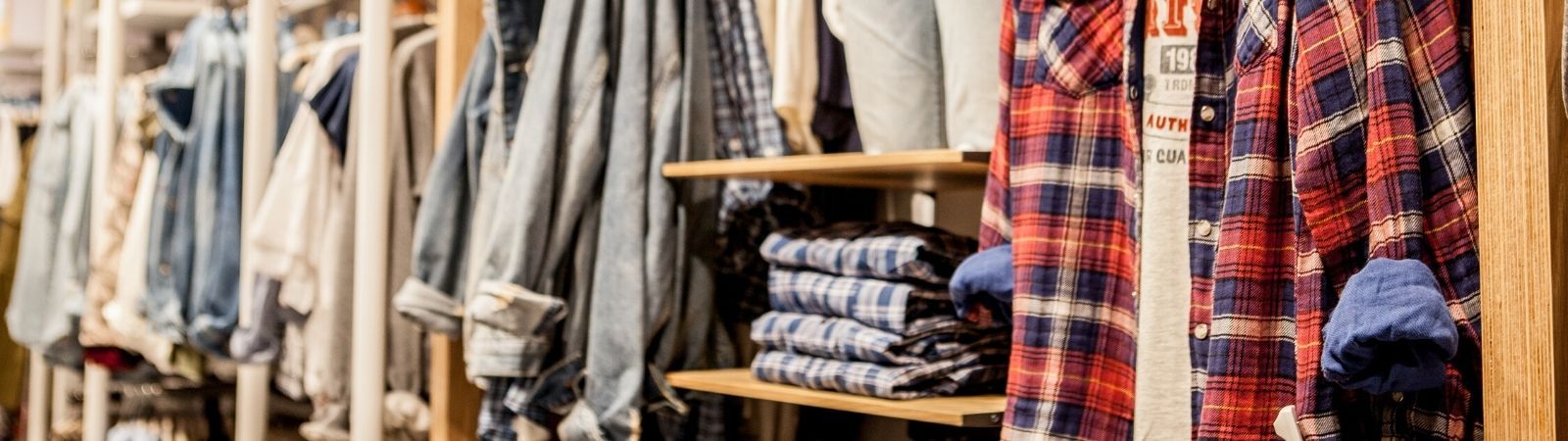 Retail store shelves showing a variety of colorful clothing, fabrics, and footwear.