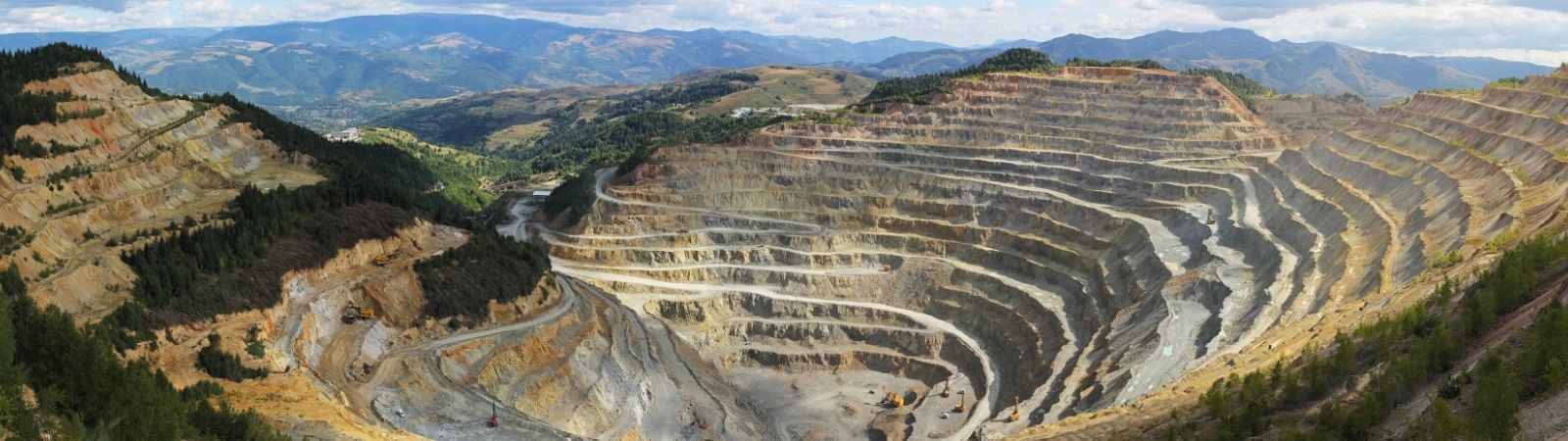 Ariel view of a conflict mineral mine nestled in the mountains with ridges.
