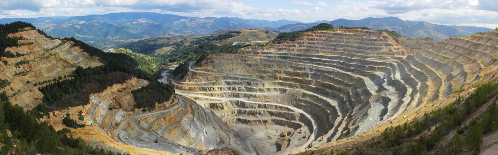 Ariel view of a conflict mineral mine nestled in the mountains with ridges.