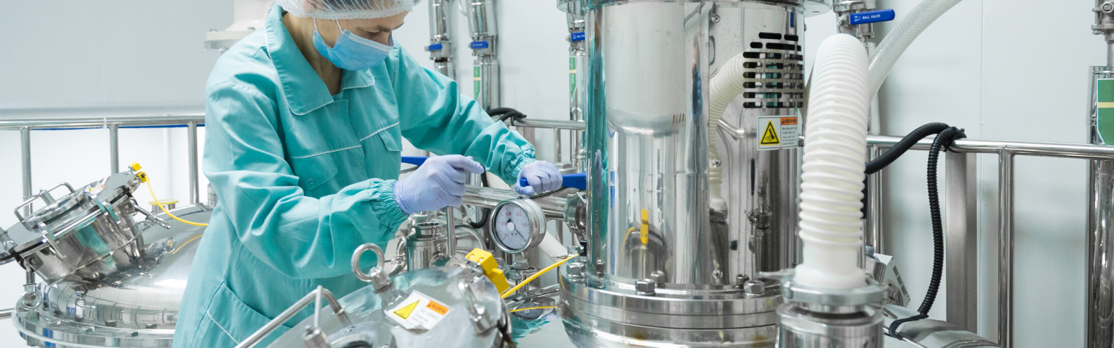 Lab tech working in a cryo tank laboratory checking the meters and recording data on a very large cryo tank.