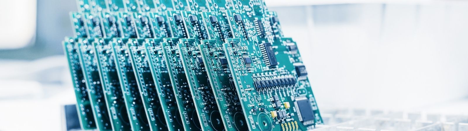 Tray of green circuit boards completed and ready for packaging in a RoHS certified manufacturing facility.