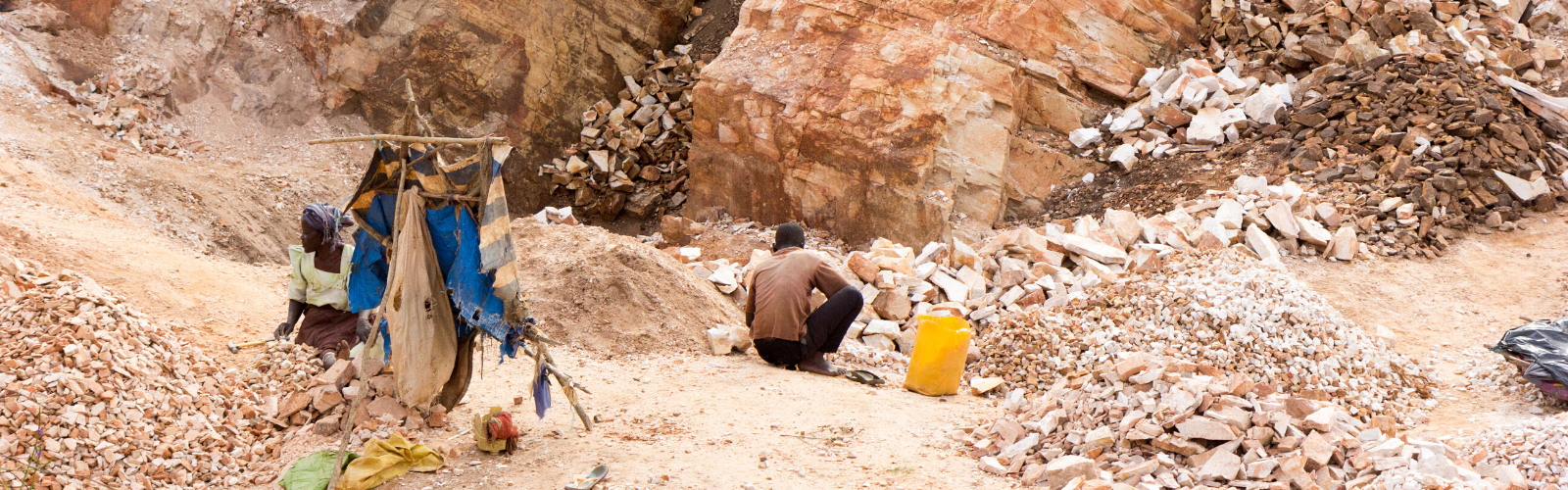 Desert mine on a relentlessly sunny day using modern day slavery with workers in tattered clothes.
