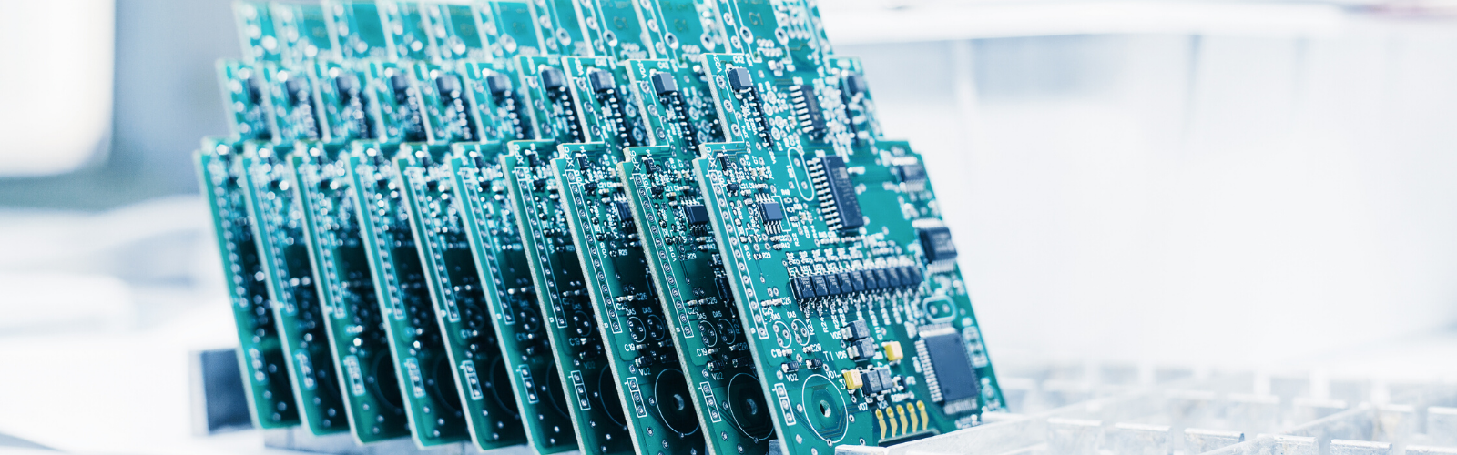 Tray of green circuit boards completed and ready for packaging in a RoHS certified manufacturing facility.