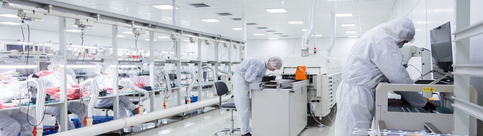Bright white laboratory with technicians working at computer reviewing safety data sheets.