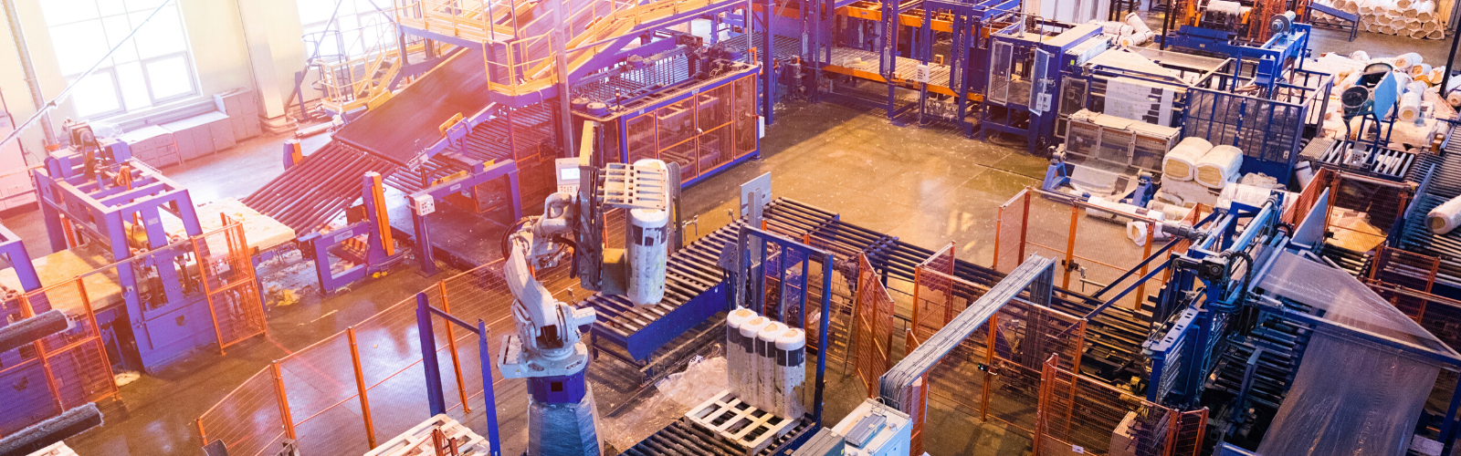 Factory floor image from above with manufacturing machines and blue and red racks.