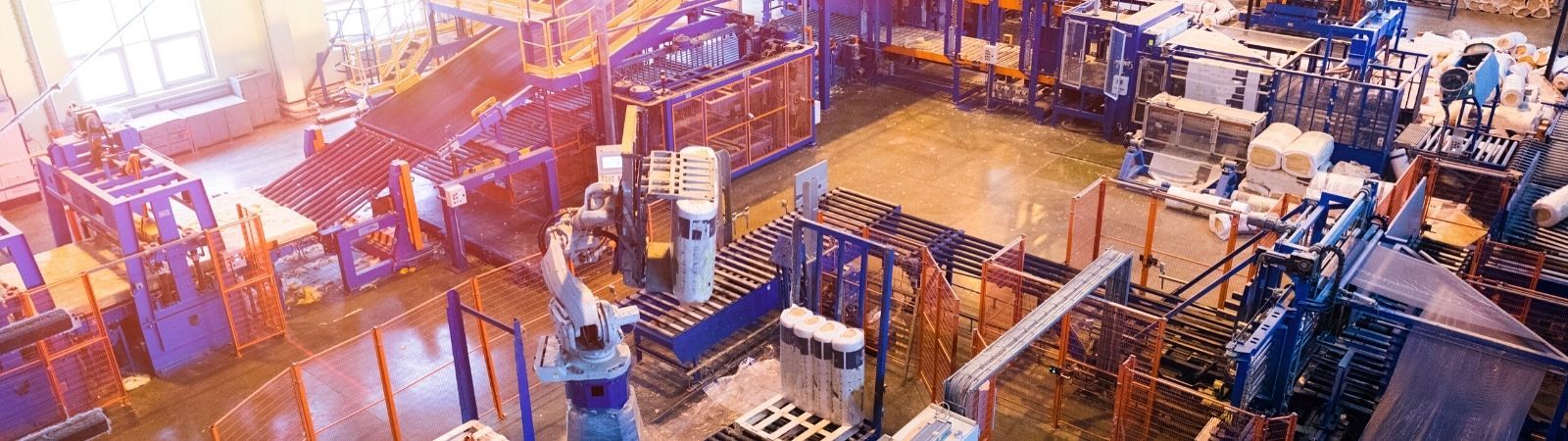 Factory floor image from above with manufacturing machines and blue and red racks.