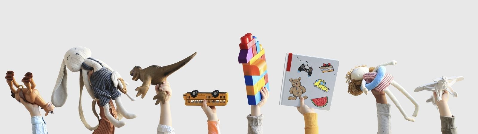 Eight children's hands holding up various toys including stuffed animals, blocks, trucks, and books on a white background.