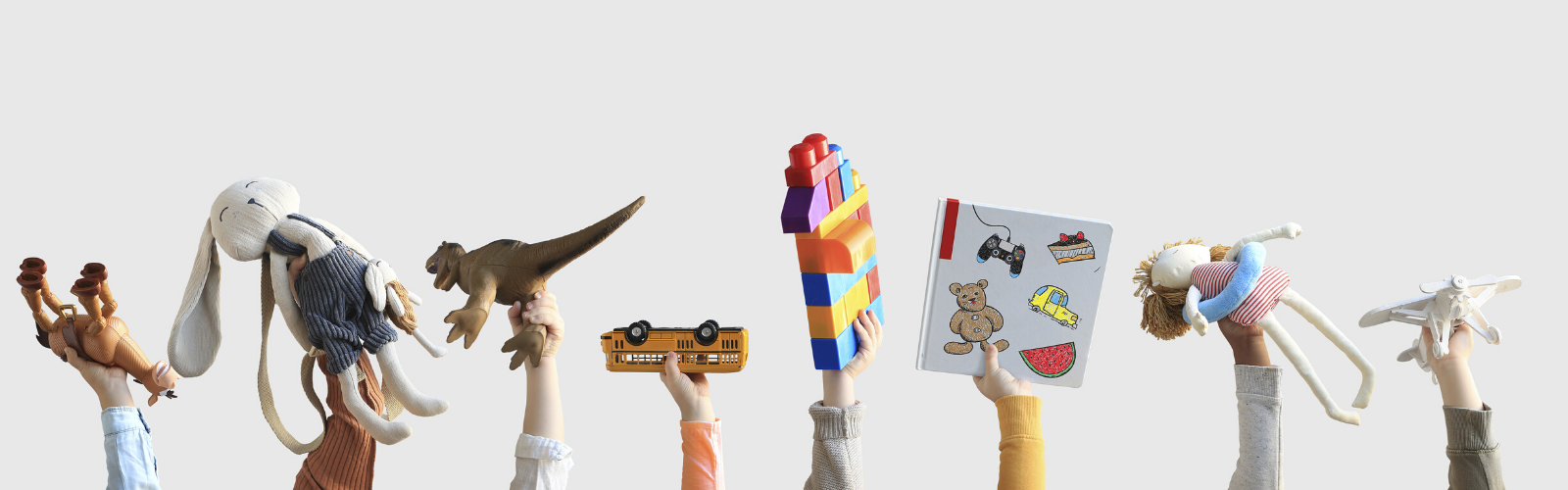 Eight children's hands holding up various toys including stuffed animals, blocks, trucks, and books on a white background.