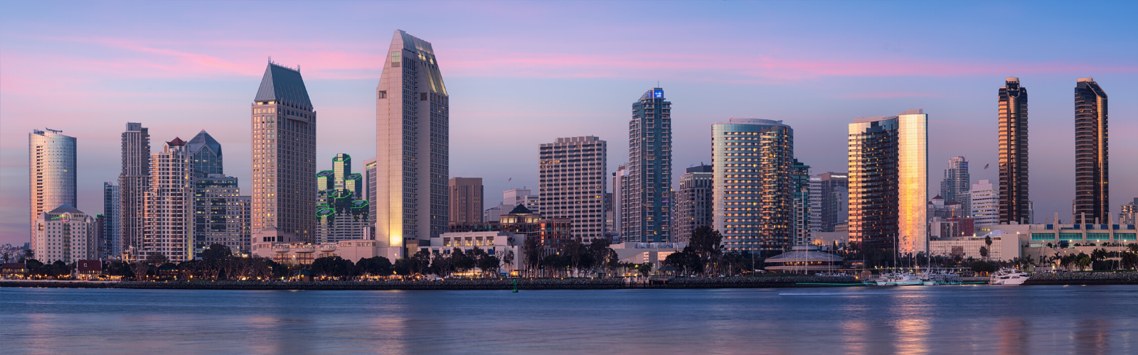 San Diego skyline image taken from the bay with a pastel sunset sky behind.