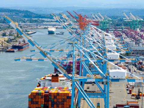 Aerial shot of a boat moving through a port waterway.