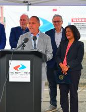 Paul Gioupis speaks at a podium