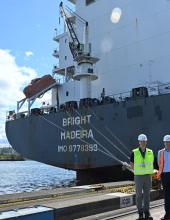 the MV bright with men in hard hats and vests standing next to it