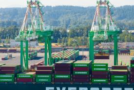 Aerial shot of cranes moving containers off a ship.