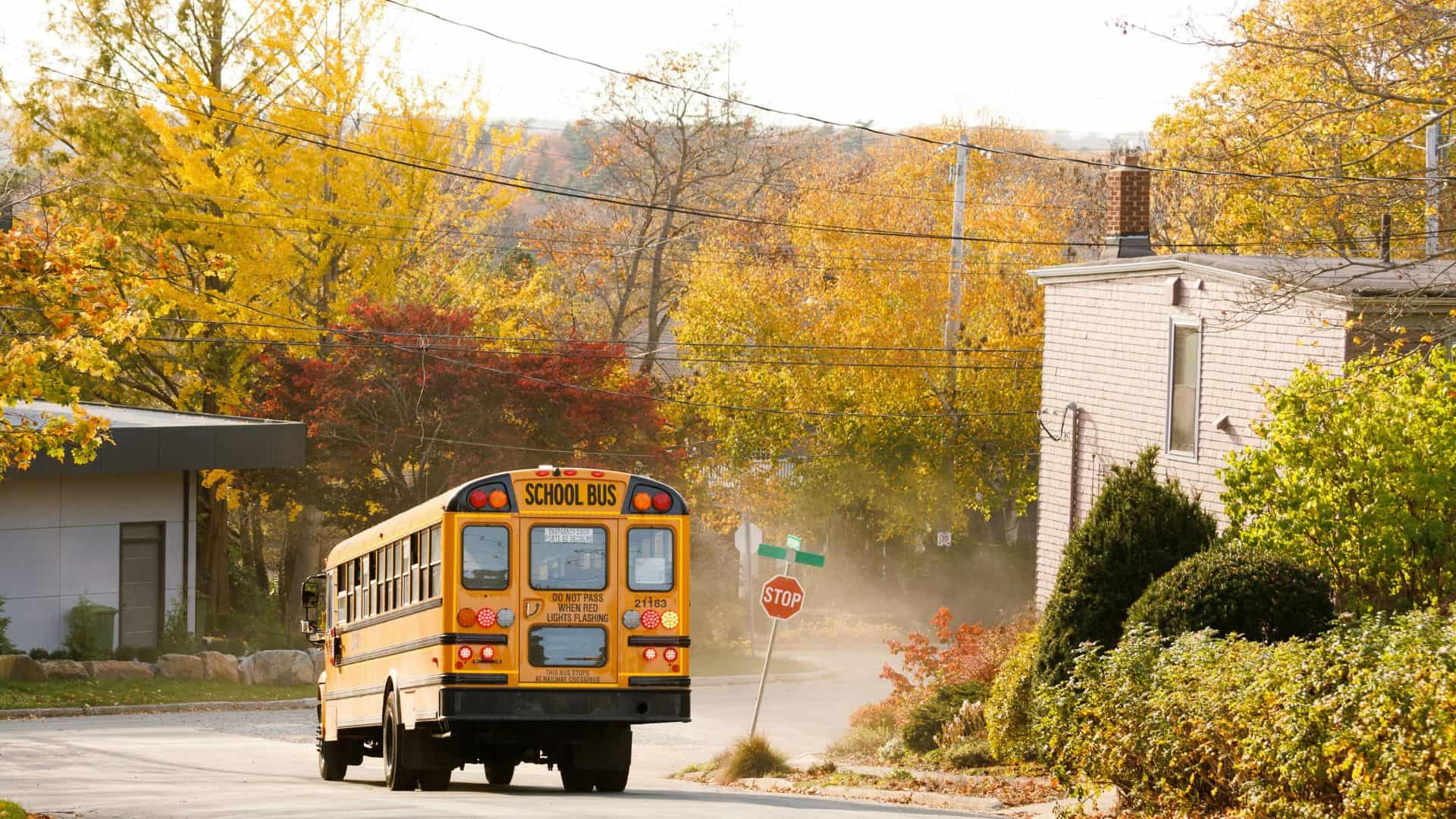Yellow school bus stopped at a stop sign.