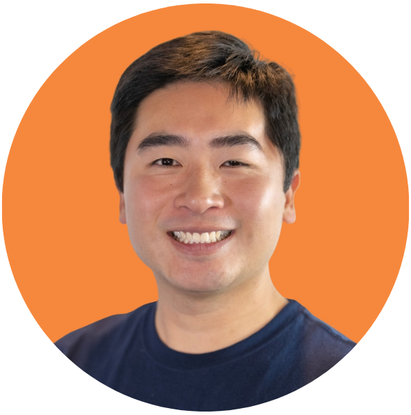 Man with short, black hair wearing navy t-shirt smiles warmly