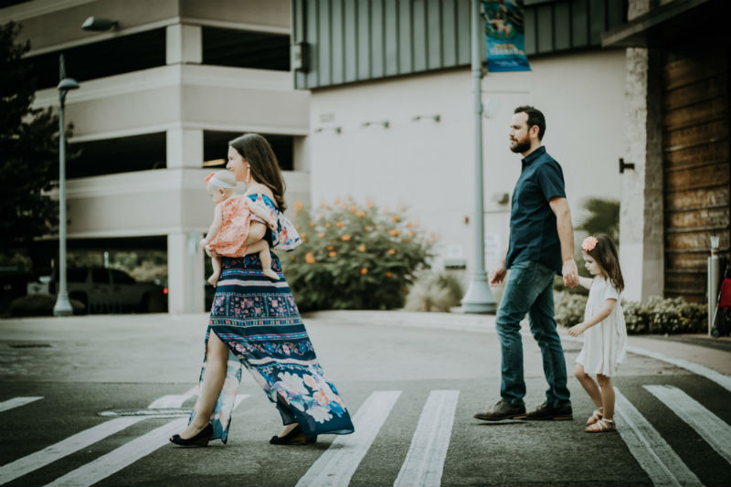 An international family of four crosses a street in the US
