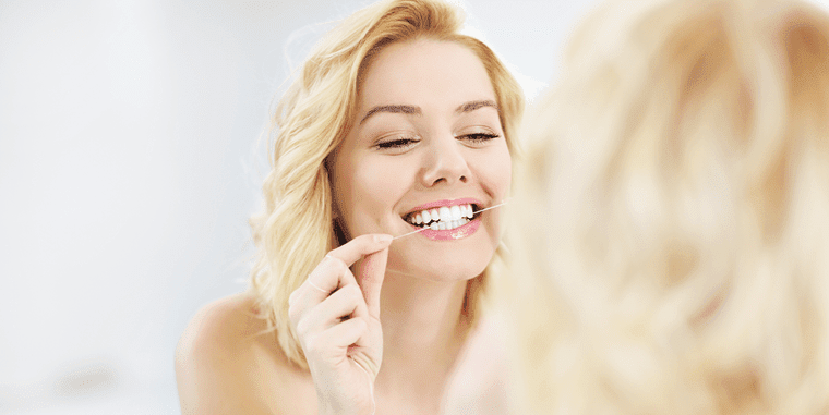 Young woman flossing her teeth