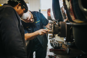 mechanics examining rotor at Bucky's Auburn Auto Repair